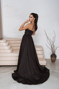 Full-length back view of black corset maxi dress showing concealed zip and dramatic train